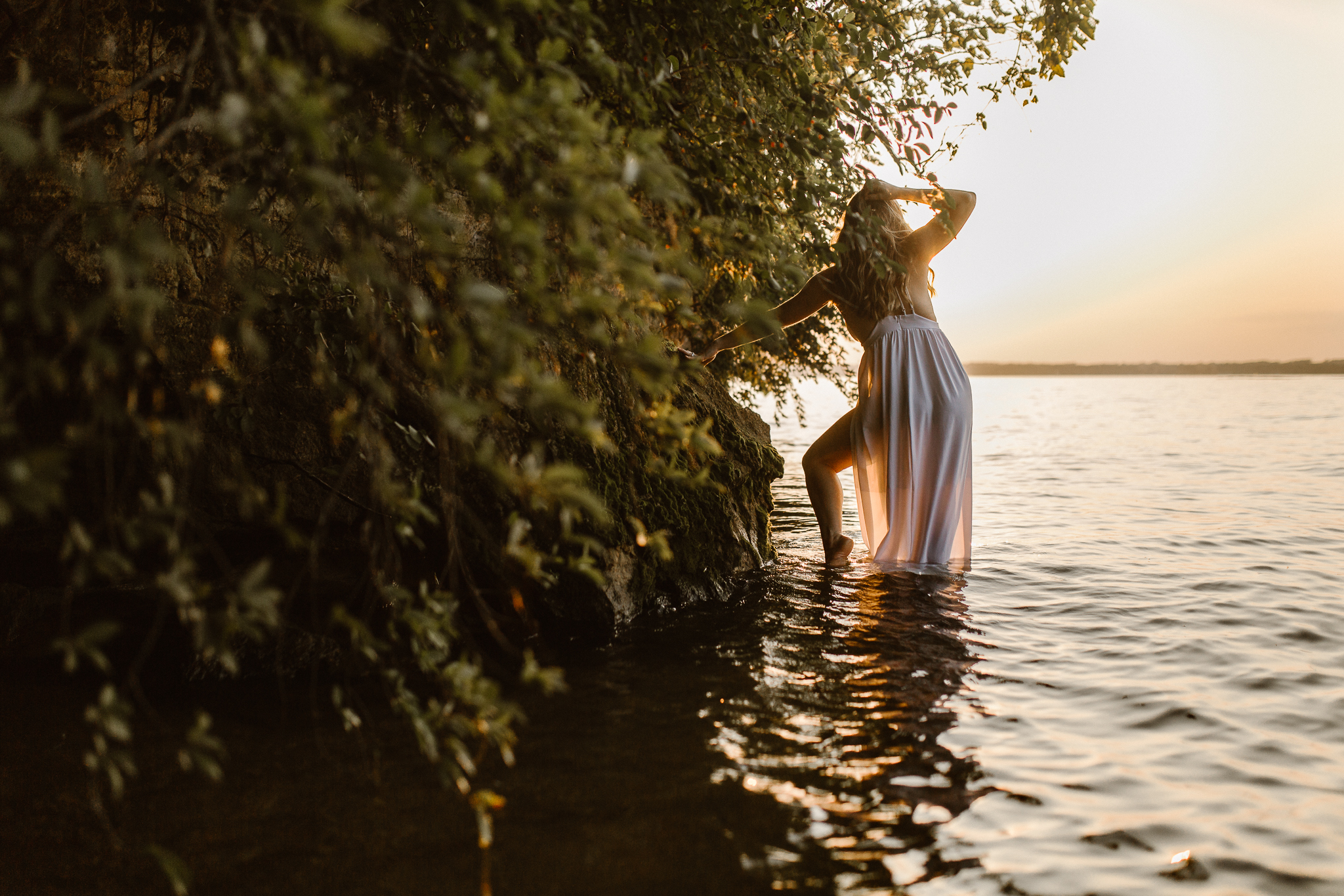 Captivating woman in an intimate lake session during a summer sunset.